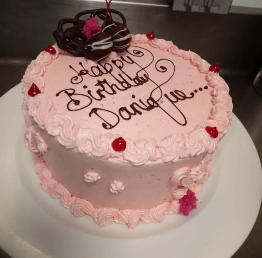 Pink birthday cake with rosettes, cherries and chocolate truffles, piped with Happy Birthday Danique